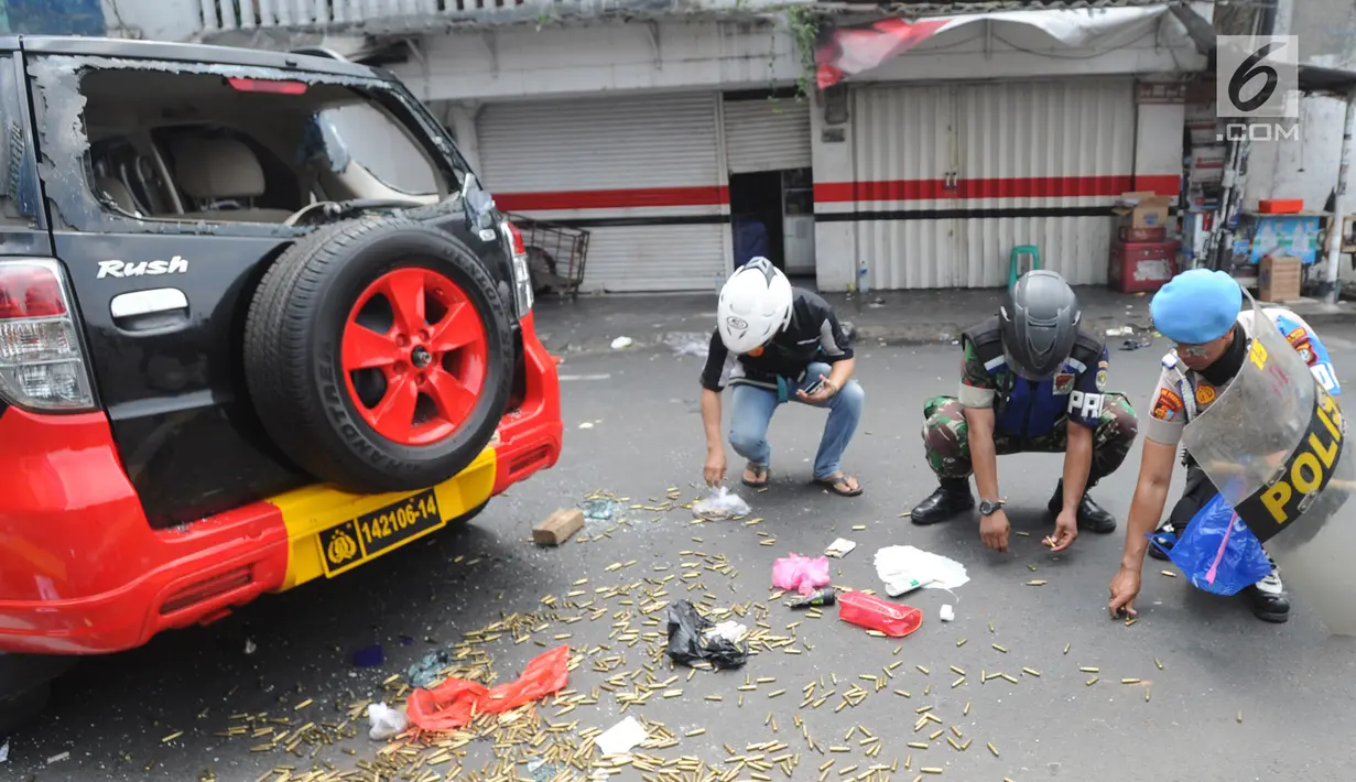 Warga, Polisi dan TNI mengambil peluru setelah kendaraan Polisi terbakar di Jalan Brigjen Katamso, Slipi, Jakarta, Rabu (22/5/2019). Belum diketahui penyebab terbakarnya dua bus yang terparkir bersama bus polisi lainnya dilokasi tersebut. (merdeka.com/Arie Basuki)