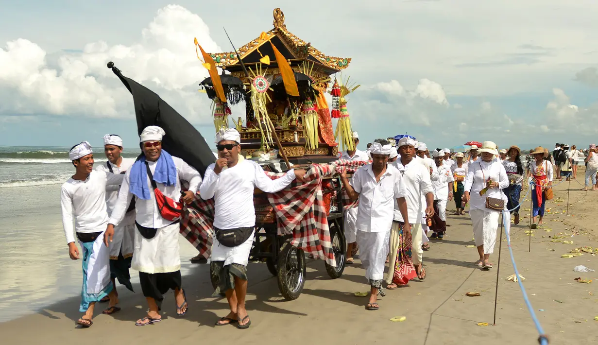 Iring-iringan umat Hindu Bali saat melakukan upacara Melasti di pantai Petitenget, Bali, Rabu (14/3). Dibeberapa kawasan seputaran Kota Denpasar terlihat umat Hindu berpakaian adat melakukan upacara Melasti. (AFP Photo/Sonny Tumbelaka)