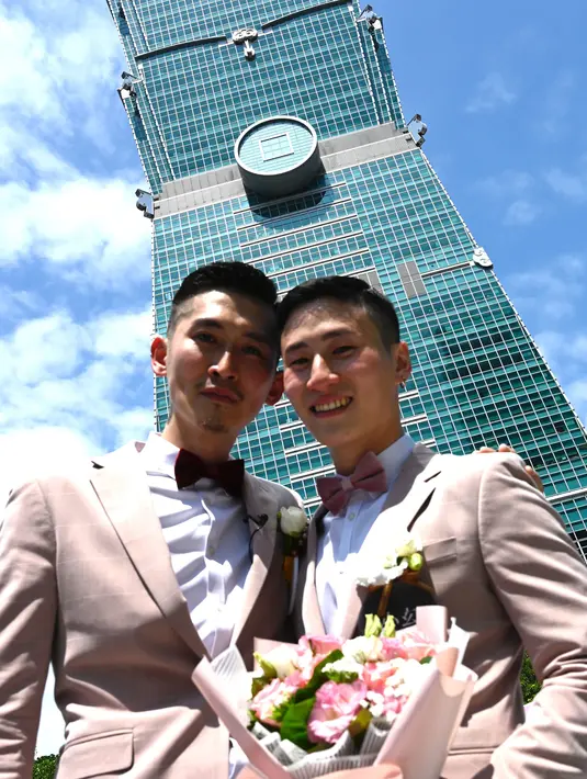 Pasangan sesama jenis Shane Lin (kanan) dan Marc Yuan berpose saat melangsungkan pesta pernikahan mereka di Taipei, Taiwan, Jumat (24/5/2019). Pernikahan pasangan sesama jenis berlangsung di Taiwan tepat saat UU LGBT mulai berlaku di tanah tersebut. (SAM YEH/AFP)