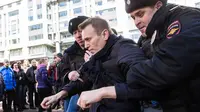 Polisi Rusia mengakap tokoh opisisi dan pengkritik keras Presiden Vladimir Putin, Aleksey Navalny, dalam unjuk rasa memprotes maraknya korupsi dalam pemerintahan, di pusat kota Moskow, (26/3). (Evgeny Feldman for Alexey Navalny's campaign photo via AP)