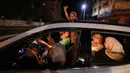 Sebuah keluarga mengemudikan mobil saat merayakan gencatan senjata antara Israel dengan Hamas di Kota Gaza, Palestina, Jumat (21/5/2021). Israel melakukan gencatan senjata dengan gerakan Islam yang berkuasa di Jalur Gaza, Hamas. (MOHAMMED ABED/AFP)
