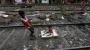 Ratan Mandal (10) bermain bersama adiknya, Bubai Tati, di rel kereta api di daerah kumuh Kolkata, India, 13 Maret 2016. Diperkirakan ada 1.000 warga yang tinggal di perkampungan kumuh di pinggir rel Kota Kolkata. (REUTERS/Rupak De Chowdhuri)