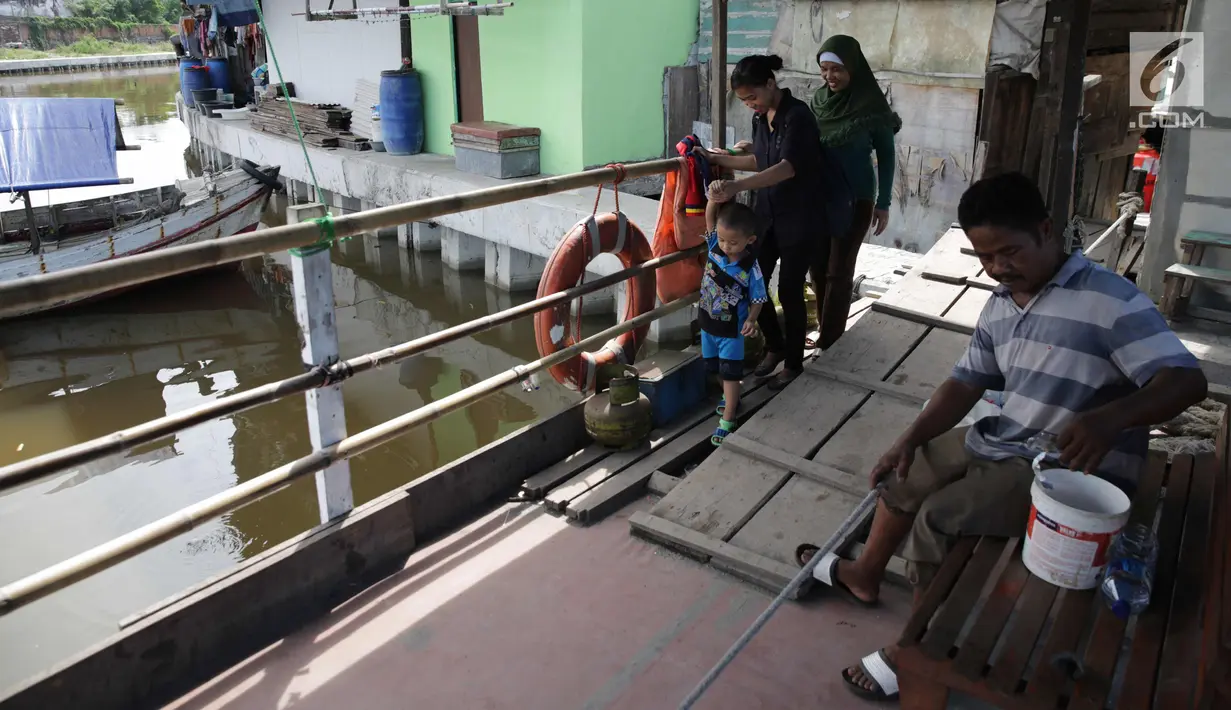 Warga menggunakan transportasi perahu eretan untuk menyebrang dari wilayah Luar Batang menuju kampung Akuarium, Jakarta, Minggu (12/11). (Liputan6.com/Faizal Fanani)