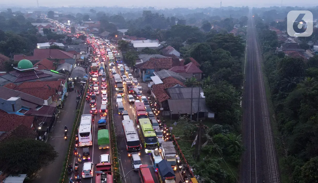 <p>Foto udara memperlihatkan kondisi lalu lintas di Simpang Jomin Pantura, Cikampek, Jawa Barat, Jumat (29/4/2022). Memasuki H-3 Idul Fitri, jalur mudik didominasi oleh kendaraan roda dua, truck dan mobil. (merdeka.com/Imam Buhori)</p>