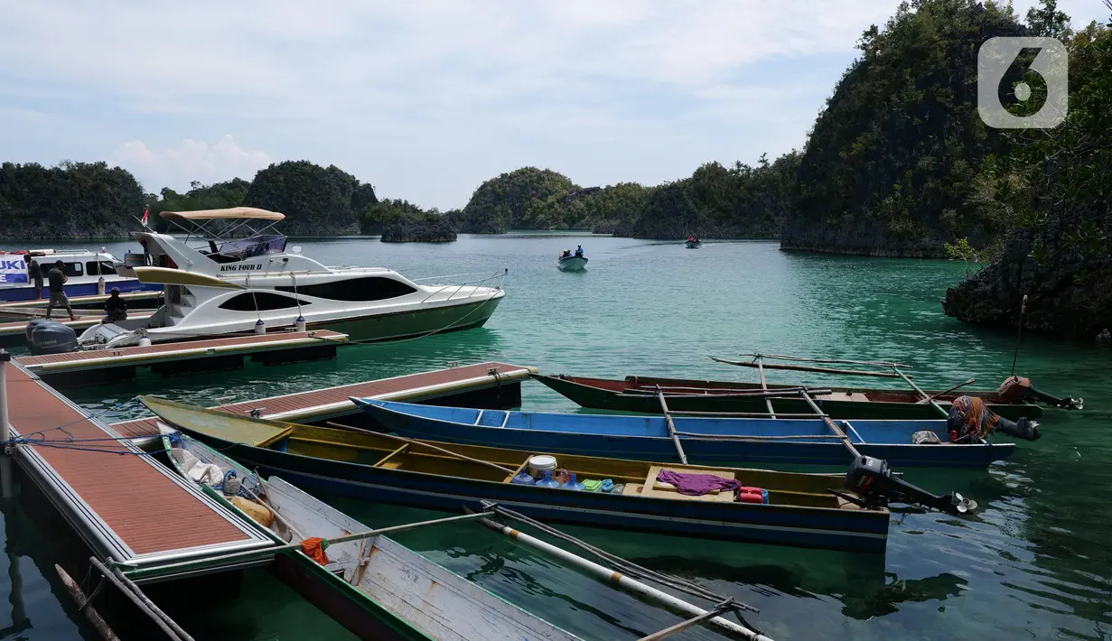 <p>Sejumlah perahu bersandar di sekitar Piaynemo, Raja Ampat, Papua Barat, Jumat (22/11/2019). Keindahan dan panorama alam masih menjadi daya tarik utama wisatawan baik lokal maupun mancanegara berkunjung ke kawasan Raja Ampat. (Liputan6.com/Herman Zakharia)</p>