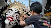 Seorang seniman Bali menciptakan sebuah patung bernama "Peringatan" saat persiapan pawai adat menjelang Hari Nyepi, di Denpasar, Bali, pada 16 Februari 2024. (SONNY TUMBELAKA/AFP)