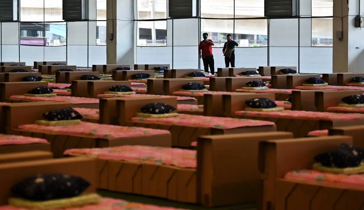 Pekerja menyiapkan kasur dan selimut untuk tempat tidur kardus di rumah sakit lapangan Covid-19 di dalam gudang Bandara Internasional Don Mueang di Bangkok, Selasa (27/7/2021). Thailand menghadapi rekor jumlah kasus virus corona di tengah kampanye vaksinasi yang lambat. (Lillian SUWANRUMPHA/AFP)