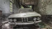 Sebuah mobil BMW yang terlihat masih cukup bagus pada bagian bampernya ini teronggok di sebuah garasi.