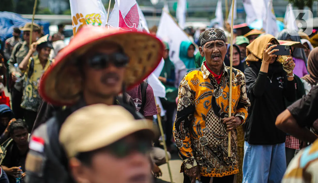 Sejumlah elemen masyarakat yang tergabung dalam buruh dan petani menggelar aksi di depan Gedung DPR, Jakarta, Selasa (27/9/2022). Aksi tersebut digelar tepat di momentum peringatan Hari Tani Nasional (HTN) 2022, 27 September. (Liputan6.com/Faizal Fanani)