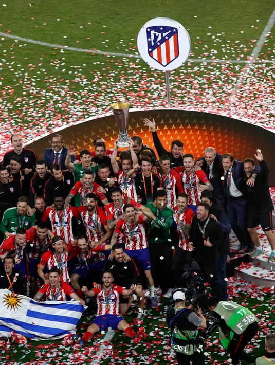 Pemain Atletico Madrid mengangkat piala saat menjadi juara Liga Europa usai mengalahkan Marseille di Stade de Lyon, Prancis (16/5). Bagi Atletico, ini adalah keberhasilan ketiga sejak menjadi juara pada 2010 dan 2012. (AP Photo / Christophe Ena)