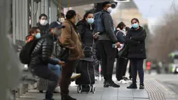 Orang-orang menunggu trem di Stasiun Flinders Street pada hari pertama wajib masker di tempat umum, di Melbourne, Kamis (23/7/2020). Penduduk kota terpadat kedua di Australia, Melbourne, diwajibkan mengenakan masker ketika meninggalkan rumah untuk mencegah penyebaran COVID-19. (William WEST/AFP)