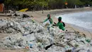 <p>Pekerja mengumpulkan sampah plastik saat membersihkan pantai Kuta dekat Denpasar di pulau wisata Bali (6/1/2021). Pada 1 Januari 2021, sekira 30 ton sampah diangkut dari kawasan Pantai Kuta dalam kegiatan bersih-bersih pantai. (AFP/Sonny Tumbelaka)</p>
