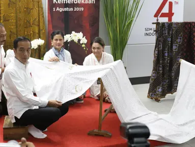 Presiden Joko Widodo didampingi Ibu Negara Iriana Jokowi saat membatik di acara batik kemerdekaan di Stasiun MRT Bundaran HI, Kamis (1/8/2019). Dalam kesempatan tersebut Jokowi berharap batik bisa dikembangkan sebagai sebuah brand. (Liputan6 com/Angga Yuniar)