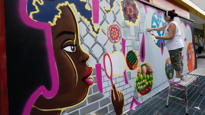 Seniman grafiti Sandra Fabara atau lebih dikenal Lady Pink melukis mural di Casita Maria, Bronx, New York, AS, Minggu (2/6/2019). Lady Pink mulai melukis grafiti pada usia 15 tahun. (Don Emmert/AFP)