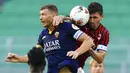 Pemain AC Milan, Alessio Romagnoli, duel udara dengan striker AS Roma, Edin Dzeko, pada laga Serie A di Stadion San Siro, Minggu (28/6/2020). AC Milan menang 2-0 atas AS Roma. (AP/Spada)