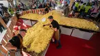 Koki memasak rosti dalam upaya memecahkan rekor dunia saat acara yang menandai peringatan 125 tahun Serikat Petani Swiss (SBV) di Bern, Swiss pada 19 September 2022. Sebagian dari rosti itu kemudian dibagikan kepada warga yang menonton acara itu. (Fabrice COFFRINI / AFP)