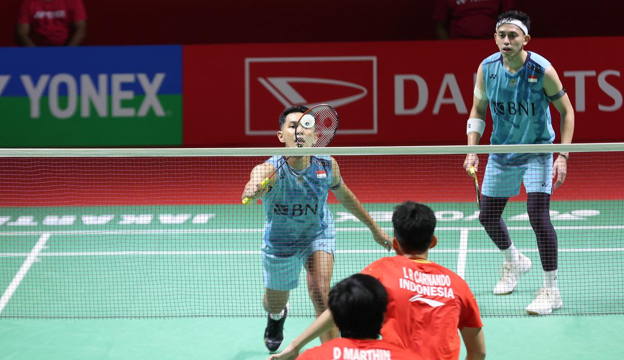Pemain ganda putra Indonesia, Fajar Alfian (kiri) yang berpasangan dengan Muhammad Rian Ardianto berusaha mengembalikan serve saat menghadapi sesama pasangan Indonesia, Leo Rolly Carnando/Daniel Marthin pada laga semifinal Daihatsu Indonesia Masters 2024 di di Istora Senayan, Jakarta, Sabtu (27/1/2024). Fajar/Rian kalah rubber game dengan skor 21-19, 14-21 dan 17-21. (Bola.com/Pradipta Rama)