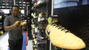 Seorang pengunjung memilih sepatu di toko Fisik Football di AEON Mall, Jakarta, Sabtu (30/9/2017). Fisik Football menjual berbagai macam perlengkapan sepak bola. (Bola.com/M Iqbal Ichsan)