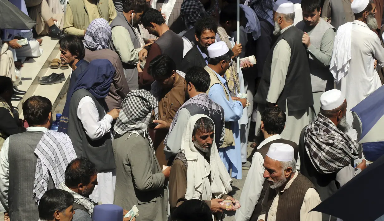Pedagang penukaran uang Afghanistan menunggu pelanggan di halaman pasar pertukaran mata uang Sarai Shahzada, menyusul pembukaan kembali bank dan pasar setelah Taliban mengambil alih kekuasaan di Kabul, pada Sabtu (4/9/2021). (AP Photo/Wali Sabawoon)