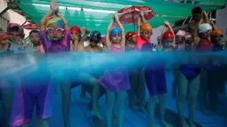 Anak-anak bersiap melakukan latihan berenang di sekolah olahraga Hangzhou Chen Jinglun Natatorium, di Hangzhou, provinsi Zhejiang, China, (10/8). (REUTERS/Aly Song)