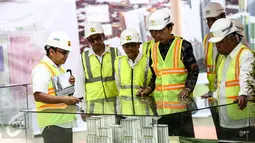 Presiden Jokowi melihat market pembangunan Rusun Atlet Asian Games XVIII saat hadir dalam pengecoran akhir atap atau topping off di Kemayoran, Jakarta, Kamis (29/12). Rusun ini terdiri dari 10 tower dengan jumlah unit 7.424. (Liputan6.com/Faizal Fanani)