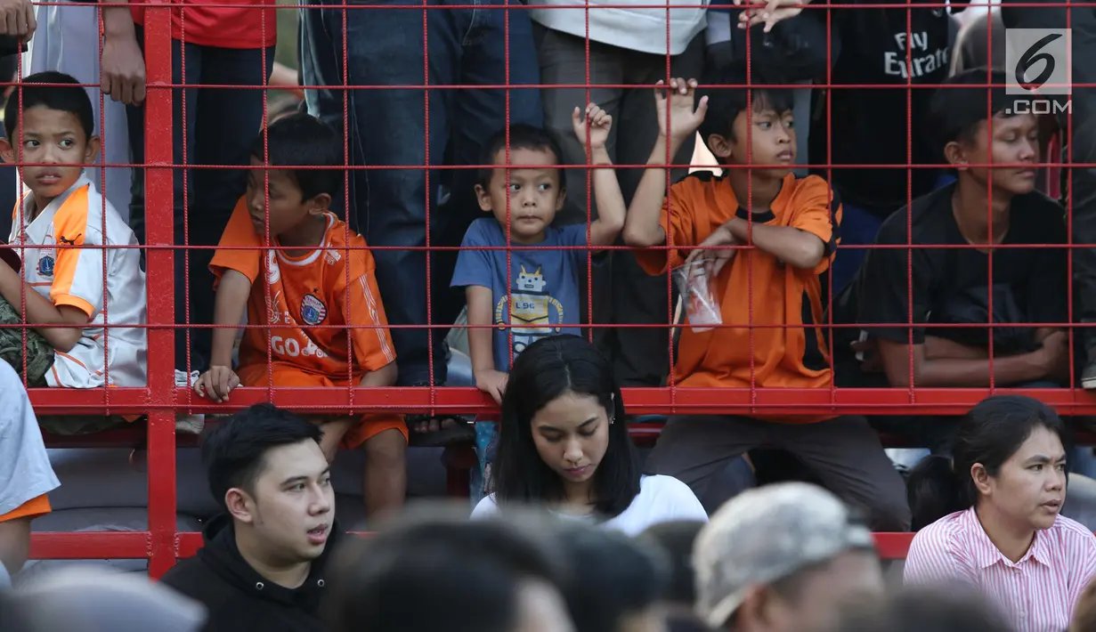 Suporter cilik tim Macan Kemayoran menyaksikan latihan perdana Persija pasca menjuarai Liga 1 musim 2018 di Lapangan Wisma Aldiron, Jakarta, Senin (7/1). 30 pemain ikut dalam latihan perdana yang digelar terbuka. (Liputan6.com/Helmi Fithriansyah)