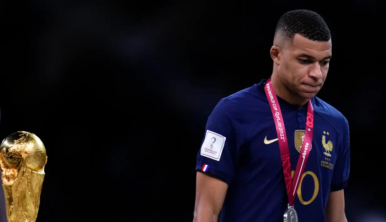 Pemain Prancis Kylian Mbappe tertunduk saat berjalan melewati trofi Piala Dunia 2022 usai melawan Argentina pada pertandingan final di Stadion Lusail, Lusail, Qatar, 18 Desember 2022. Argentina menang 4-2 dalam adu penalti melawan Prancis setelah pertandingan berakhir imbang 3 -3. (AP Photo/Manu Fernandez)