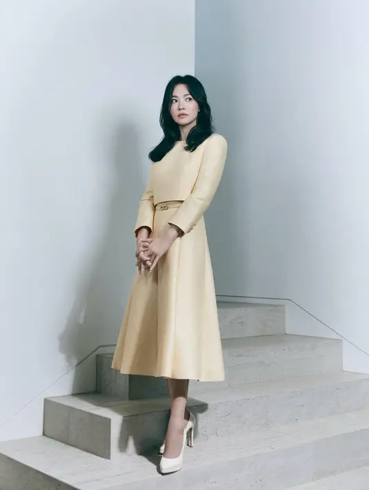 Elegannya Song Hye Kyo pakai setelan atasan dan bawahan yang serasi. Structured set bernuansa kuning pastel ini terdiri dari atasan lengan panjang dan midi skirt, dengan detail belt kecil yang manis, dipadu dengan high heels putih. [Foto: Instagram/kyo1122]