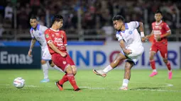 Pemain PSBS Biak, Muhammad Tahir (kanan) melepaskan tendangan ke gawang Semen Padang pada laga leg kedua final Pegadaian Liga 2 2023/2024 di Stadion GOR Haji Agus Salim, Padang, Sabtu (9/3/2024). (Bola.com/Bagaskara Lazuardi)