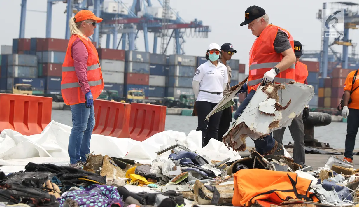 Petugas KNKT mencari dan memisahkan serpihan pesawat Lion Air JT 610 dari tumpukan barang temuan di Pelabuhan JICT 2, Jakarta, Kamis (1/11). Sebelumnya, pesawat Lion Air JT-610 jatuh diperairan utara Kerawang. (Liputan6.com/Helmi Fithriansyah)