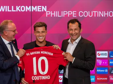 Pemain baru Bayern Munchen Philippe Coutinho (tengah) memegang jersey timnya bersama CEO Karl-Heinz Rummenigge (kiri) dan pelatih Hasan Salihamidzic saat konferensi pers di Munich, Jerman, Senin (19/8/2019). Coutinho resmi menjadi pemain Bayern Munchen musim 2019-2020. (Peter Kneffel/dpa via AP)