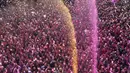 Umat Hindu bersorak saat bubuk berwarna dan air disemprotkan selama perayaan Festival Holi di kuil Kalupur Swaminarayan di Ahmedabad, India (18/3/2022).  Holi, festival warna Hindu, juga menandai datangnya musim semi. (AP Photo/Ajit Solanki)