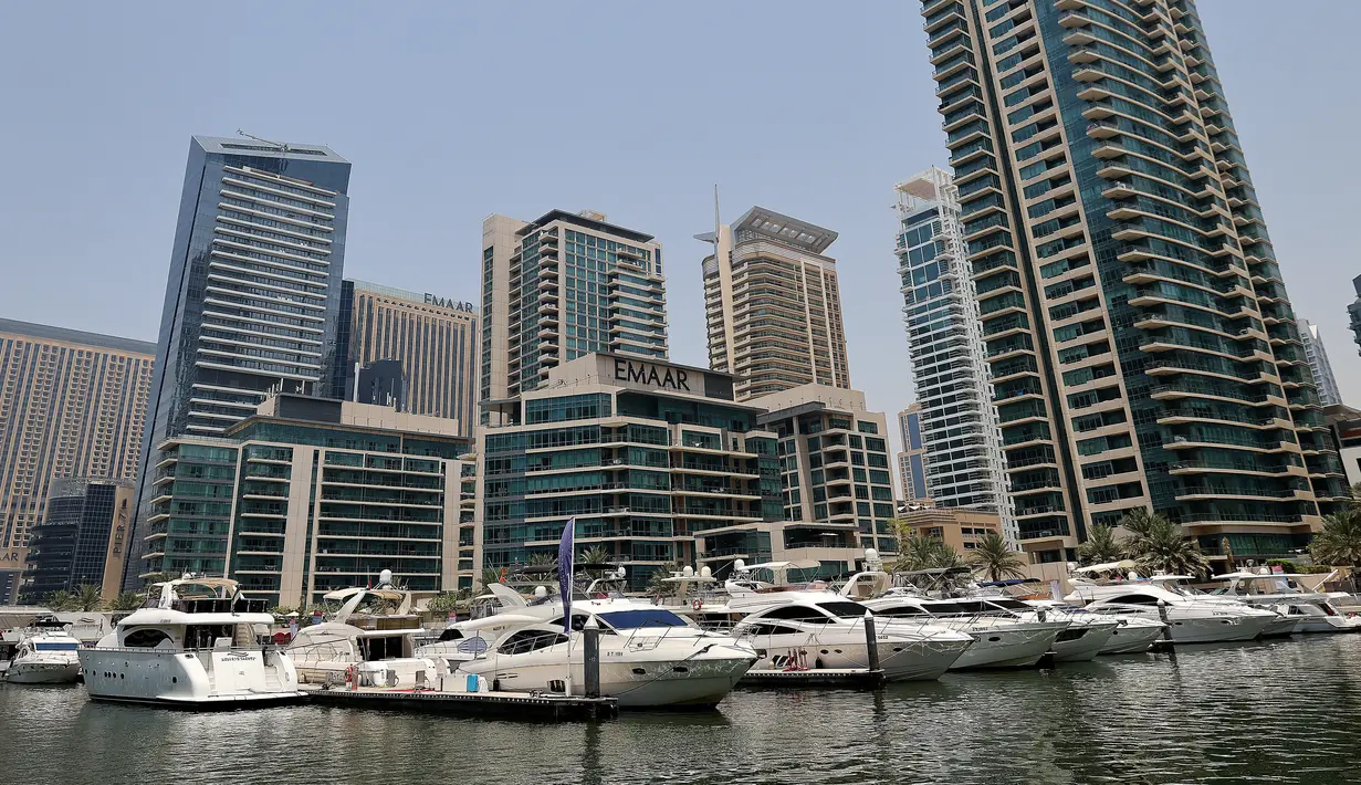 Kapal pesiar mewah bersandar di Dubai Marina Beach di emirat Teluk, pada 10 Juni 2021. Di tengah aturan pandemi di mana warga harus menjaga jarak dan menghindari keramaian, orang-orang kaya di Dubai memiliki cara mereka bisa pergi berekreasi, yaitu jalan-jalan dengan kapal pesiar. (Karim SAHIB/AFP)