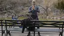 Seorang pria memanfaatkan cuaca hangat untuk berolahraga di luar di Morningside Park di New York (11/3/2021).  Cuaca hangat yang tidak wajar membuat warga New York keluar setelah awal tahun bersalju. (AP Photo / Seth Wenig)