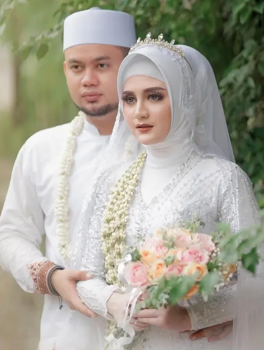 Ketika menikah dengan Noval KDI, Irenne Ghea tampak mengenakan kebaya putih. Di hari pernikahannya pada Januari 2021, ia memilih tampil anggun dalam balutan hijab berwarna senada dengan kebayanya. Makeup bold yang menghiasi wajahnya pun membuat Irenne terlihat cantik.(Liputan6.com/IG/@noval_kdi)