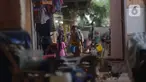 Penjual jamu gendong melintasi permukiman warga di Kawasan Penjaringan, Jakarta, Sabtu (23/11/2019). Bank Dunia mengukur tingkat kemiskinan dengan batas Upper Middle-Income Clas atau kelas menengah mempunyai pendapatan US$ 5,5 atau setara Rp 77 ribu per hari. (merdeka.com/Imam Buhori)