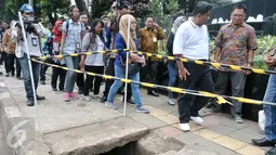 Plt Gubernur DKI Jakarta Sumarsono (baju putih) bersama rombongan saat akan meninjau pembersihan gorong-gorong di Jalan Gatot Subroto, Jumat (10/3). Sumarsono memantau langsung proses pengerukan gorong-gorong di kawasan itu. (Liputan6.com/Yoppy Renato)