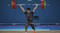 Atlet angkat besi Indonesia, Rizki Juniansyah berhasil mengangkat beban seberat 199 kg pada angkatan clean and jerk saat berlomba pada kelas 73 kg putra cabor angkat besi Olimpiade Paris 2024 di Paris Expo Porte de Versailles, Paris, Kamis (8/8/2024). (AP Photo/Kin Cheung)