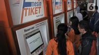 Calon penumpang membeli tiket kereta Mudik Lebaran 2020 melalui mesin E-Kios di Stasiun Pasar Senen, Jakarta, Senin (17/2/2020). PT Kereta Api Indonesia resmi membuka penjualan tiket Mudik Lebaran 2020 mulai 14 Februari 2020. (merdeka.com/Iqbal Nugroho)