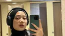 Zara melakukan mirror selfie. Dia mengenakan blouse yang dipadukan dengan jaket kulit dan jilbab hitam. Tampilannya begitu modis. (Foto: Instagram/ camilliazr)