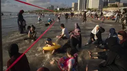 Warga Palestina berbaur dengan warga Israel di pantai Tel Aviv. (AP Photo/Oded Balilty)