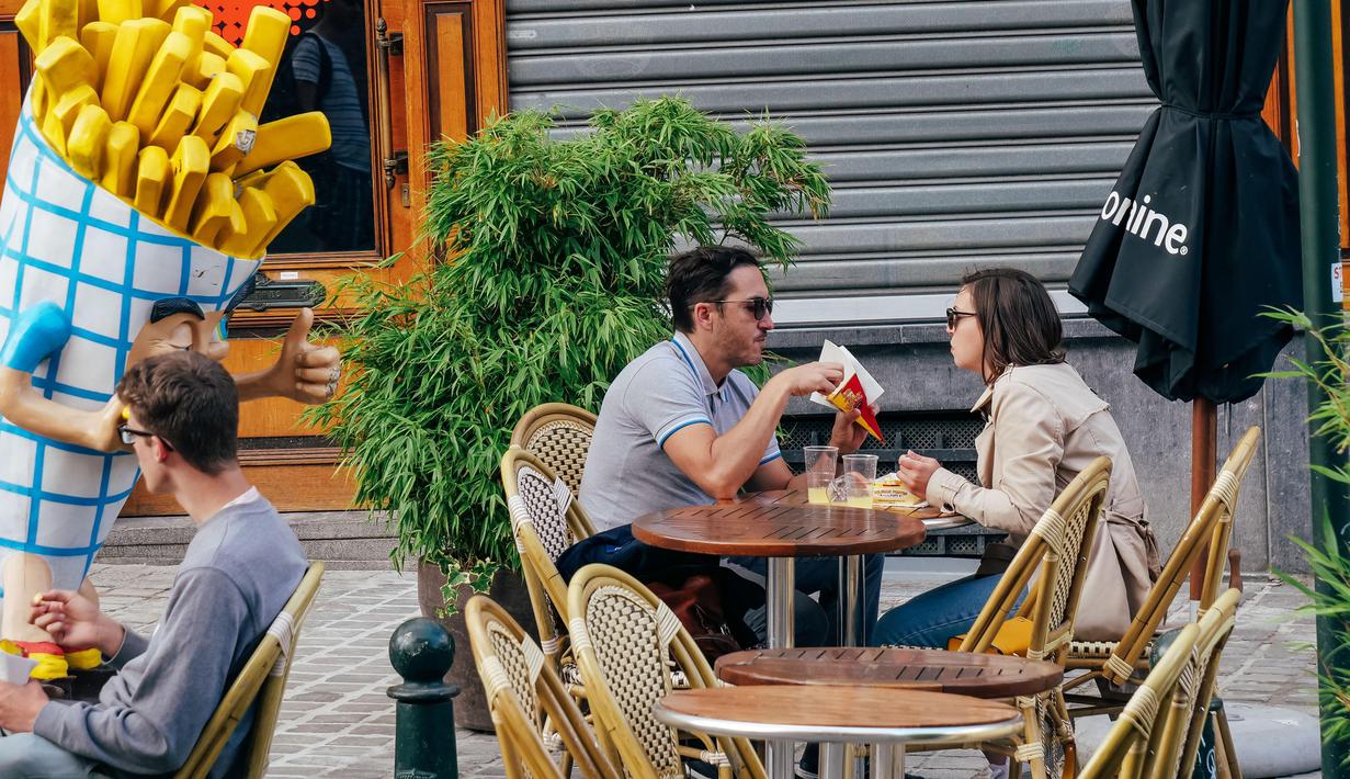 Sejumlah orang menyantap kentang goreng di sebuah kedai di Brussel, Belgia, 28 Juni 2020. Komisi Eropa memprediksi Ekonomi Eropa akan menghadapi resesi lebih dalam akibat langkah-langkah pengendalian COVID-19 yang berkepanjangan. (Xinhua/Zhang Cheng)