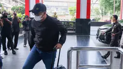 Bupati Klaten Hamenang Wajar Ismoyo tiba di Gedung Merah Putih KPK dengan mengenakan pakaian kasual, topi hitam, kacamata, dan masker putih, Jumat (16/10/2026). Ia langsung memasuki gedung tanpa memberikan keterangan kepada awak media. (officialkpkri)
