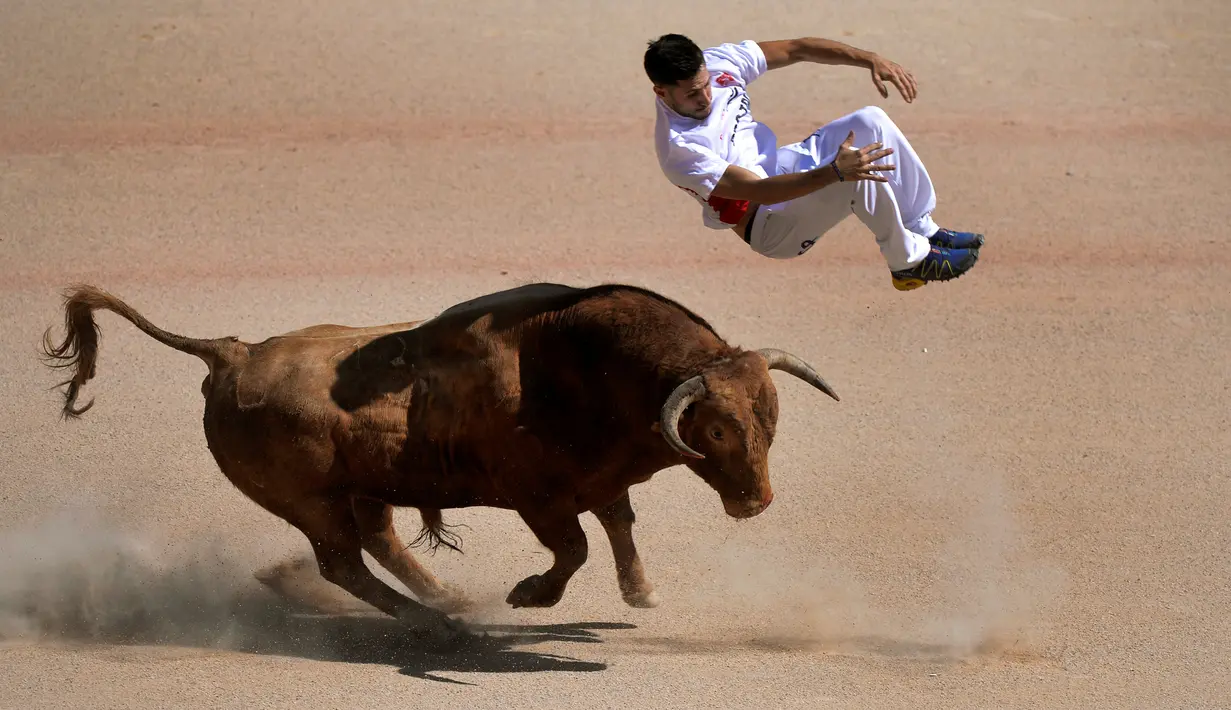 Seorang recortador melompati serudukan banteng selama Festival San Fermin di Pamplona, Spanyol, Sabtu (9/7).Festival yang sempat mengalami kecaman dari aktivis hewan ini tetap menjadi tontonan menarik warga Spanyol. (REUTERS / Vincent West)