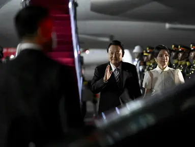 Presiden Korea Selatan Yoon Suk Yeol dan istrinya Kim Keon-hee tiba di Bandara Internasional Ngurah Rai di Bali, Minggu, 13 November 2022. Presiden Yoon Suk Yeol yang ditemani istri cantiknya Kim Keon-hee berencana menghadiri pertemuan puncak KTT G20 di Nusa Dua di Bali. (Sonny Tumbelaka/Pool Photo via AP)