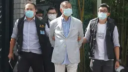 Taipan media Hong Kong, Jimmy Lai (tengah) ditangkap oleh aparat kepolisian di rumahnya di Hong Kong, Senin (10/8/2020). Pendiri surat kabar lokal Apple Daily itu ditangkap atas tuduhan pelanggaran Undang-Undang Keamanan Nasional Hong Kong karena dianggap berkolusi dengan kekuatan asing. (AP Photo)