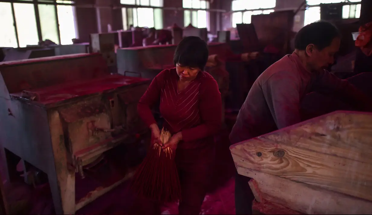Gambar pada 11 Desember 2019 menunjukkan pekerja membuat dupa di di Pabrik Dupa Fujian Xingquan, Provinsi Fujian, China. Penduduk setempat mengklaim satu dari setiap tiga batang dupa yang dijual di Asia Tenggara dibuat di Yongchun, daerah pegunungan di Provinsi Fujian tenggara. (HECTOR RETAMAL/AFP)