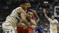 Bintang Milwaukee Bucks Giannis Antetokounmpo (kiri) berjibaku dengan guard Philadelphia 76ers Ben Simmons pada laga NBA di BMO Harris Bradley Center, Senin (29/1/2018) atau Selasa (30/1/2018) WIB. (AP Photo/Tom Lynn)