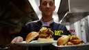 Pemilik restoran, Collin Kelly memperlihatkan burger "Durty Donald" dan "Kim Jong Yum"  yang baru dibuat di Hanoi, Vietnam, 24 Februari 2019. Restoran ini membuat 2 jenis burger khusus untuk menyambut kedatangan Kim Jong-un dan Donald Trump. (AP/Hau Dinh)