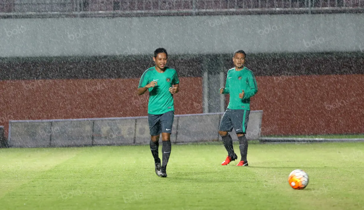 Evan Dimas dan Dedi Kusnandar melawan hujan pada sesi latihan uji coba lapangan di Stadion Maguwoharjo, Sleman, Sabtu (08/10/2016). (Bola.com/Nicklas Hanoatubun)